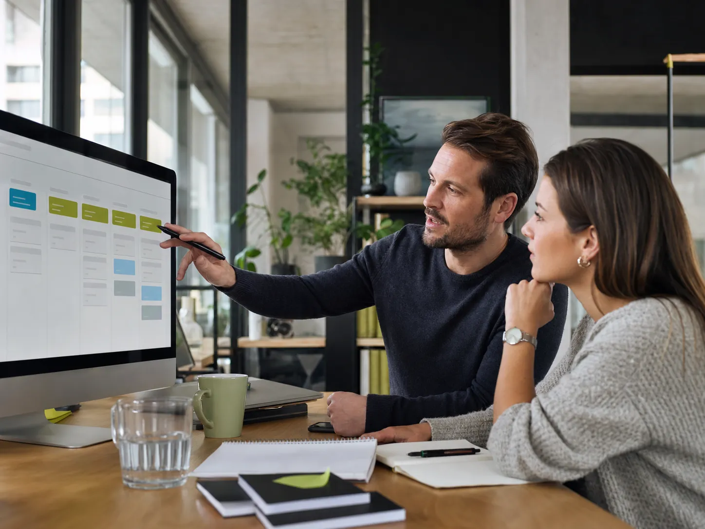 Vertriebsteam bespricht Kundenphasen und nächste Schritte an einem Monitor